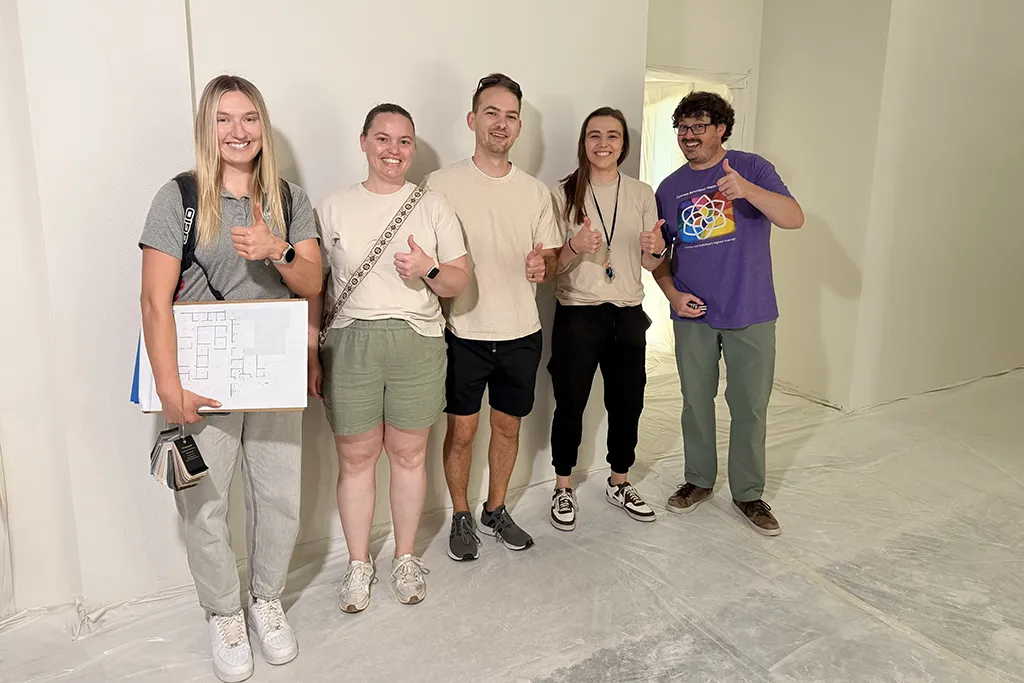 Group photo of five members of the Cultivate team in a room with white walls