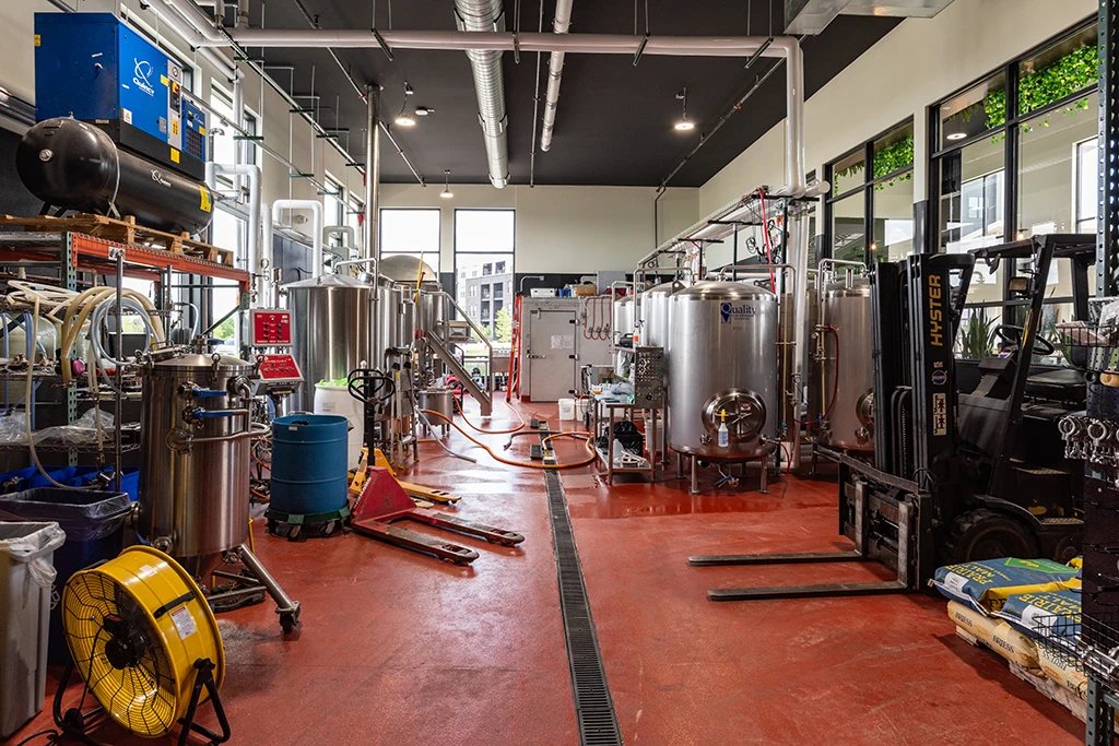 Brewing area with red floor and large silver tanks
