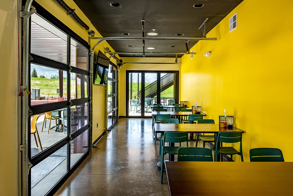 Dining area with large windows and bright yellow walls