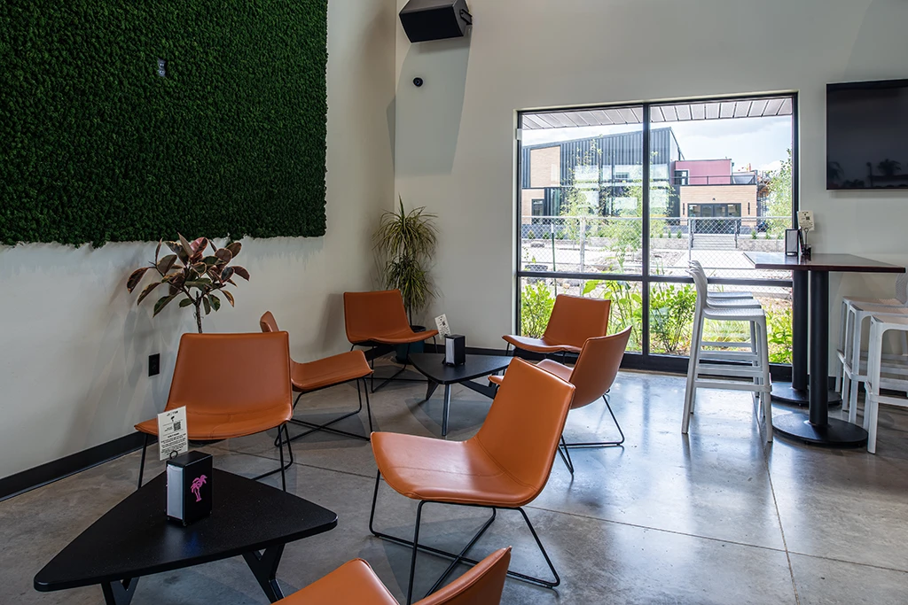 Seating area with brown chairs, triangular tables, large windows