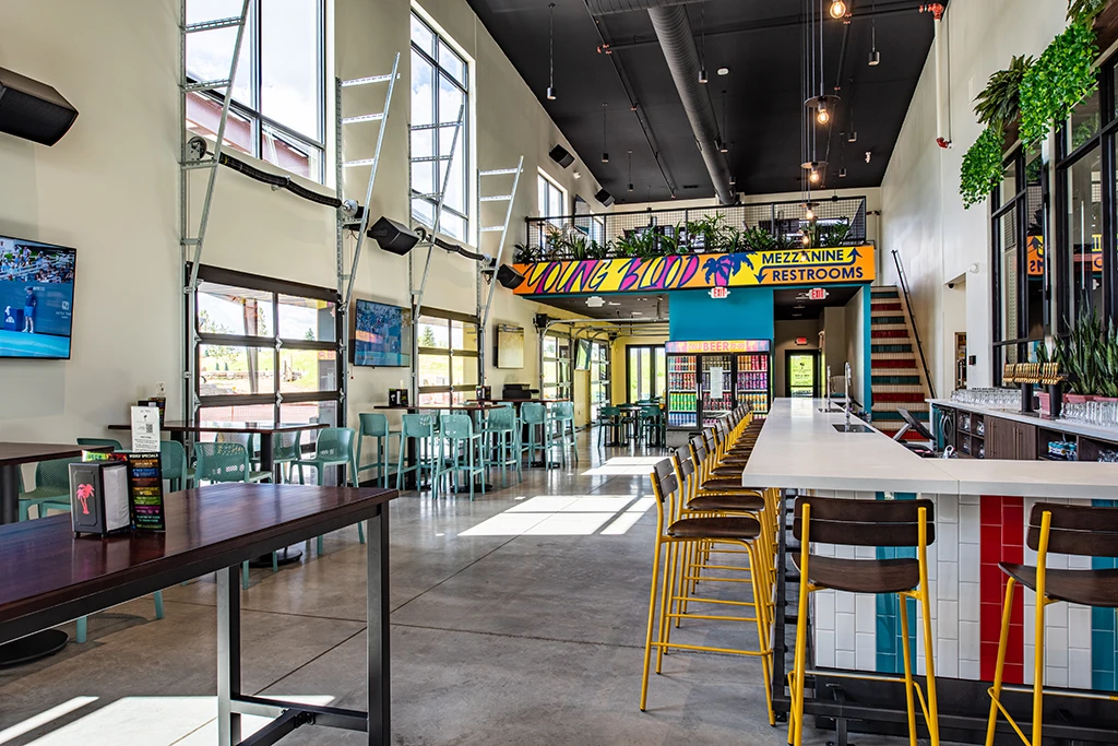 Dining area with bar, tables, and mezzanine and black ceiling