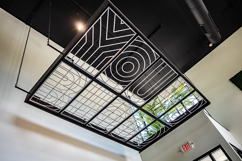 Metal trellis hanging from ceiling that spells out Young Blood
