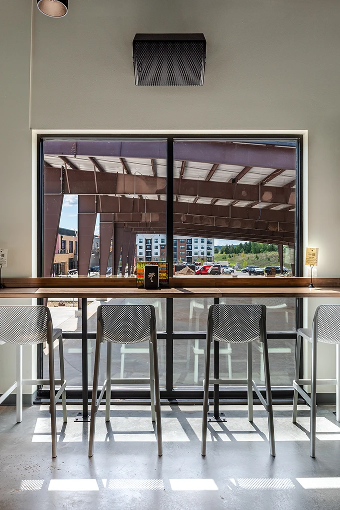 Counter and chairs across large window with ice rink visible