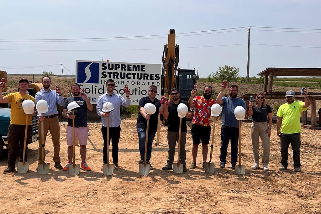 Group of people outside with shovels, hard hats, and Young Blood beers toasting the groundbreaking of the Young Blood Beer Co DeForest Craft Brewery & Taproom